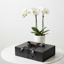 Load image into Gallery viewer, A matte black rectangular gift box tied with a black satin ribbon printed with the brand name 'EKA' in gold, shown on a plain white background.
