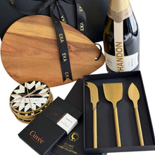Load image into Gallery viewer, A luxury gift basket hamper featuring a wooden serving board, a bottle of Chandon Brut, a boxed set of gold-toned cheese knives, and couverture Cuvee chocolate, Clinq diamond inlay coasters
