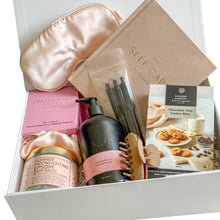 Load image into Gallery viewer, Gift hamper containing light brown hair claw, sleep mask with draw string bag, 3 black pens, Random harvest chocolate chip cookie bites, Scarlet and Grace body wash in champagne and strawberries, peppermint grove candle, bath salts and a self-care book
