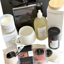 Load image into Gallery viewer, Black magnetic gift box with black five-minute journal, hand-poured candle, Cuvee classic dark hot chocolate, cuvee couverture chocolate, white hug mug, self-care kit and hand and body wash
