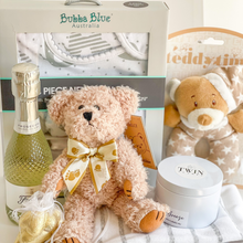 Load image into Gallery viewer, Congratulations Mum and Baby Gift Box  Included in this gift box:   Bubba Blue 4 Piece Newborn Set   Bonds Short Sleeve body suit Size 3-6 months (size 00)   Teddy Bear ring rattle (16cm)   Light brown teddy bear soft toy (20cm)   Soy candle tin by Twin Flames (Very Vanilla, French pear or coastal breeze randomly selected)   6 x Belgian chocolate hearts in gold   Presented in a white keepsake gift box and our signature blue satin ribbon 
